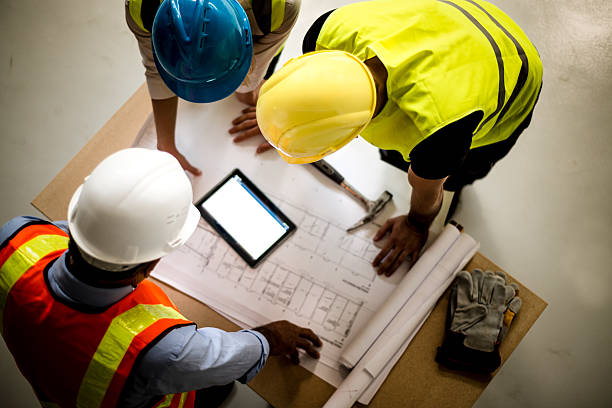A CDM principal designer reviewing construction site plans